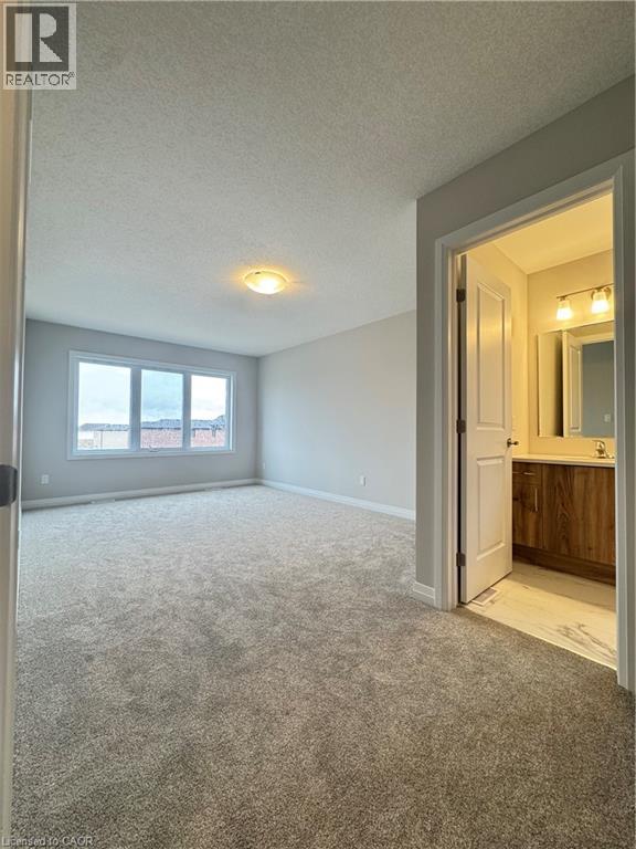 A spacious room with a carpeted floor and a doorway leading to another room.