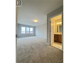 A spacious room with a carpeted floor and a doorway leading to another room.