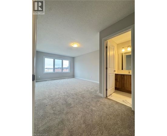 A spacious room with a carpeted floor and a doorway leading to another room.