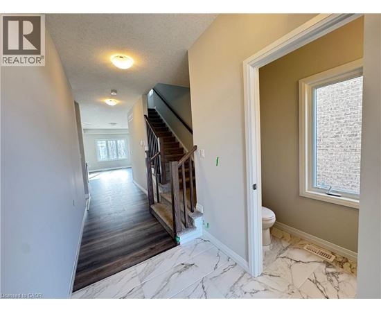 A room with a staircase and a toilet.