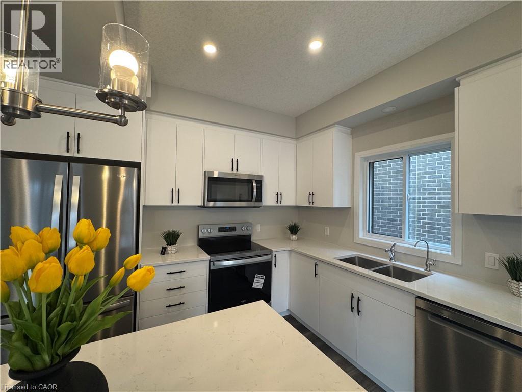 A kitchen with white cabinets and a stainless steel refrigerator.