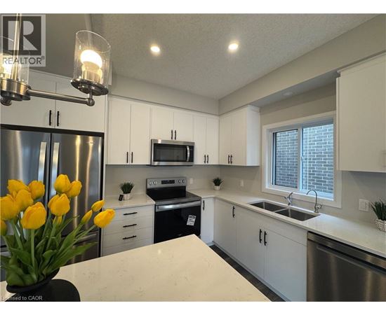 A kitchen with white cabinets and a stainless steel refrigerator.