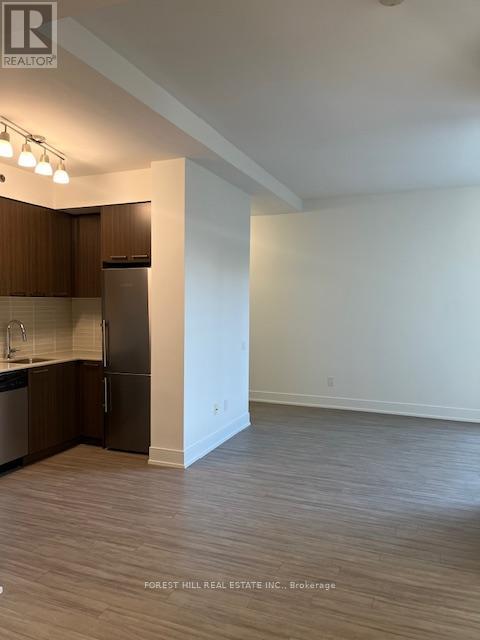 A kitchen with wooden cabinets and a refrigerator.