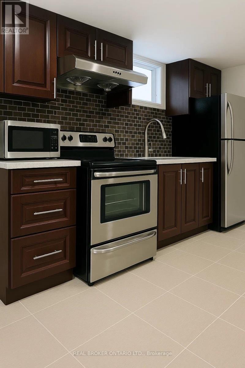 A kitchen with brown cabinets and a black refrigerator.