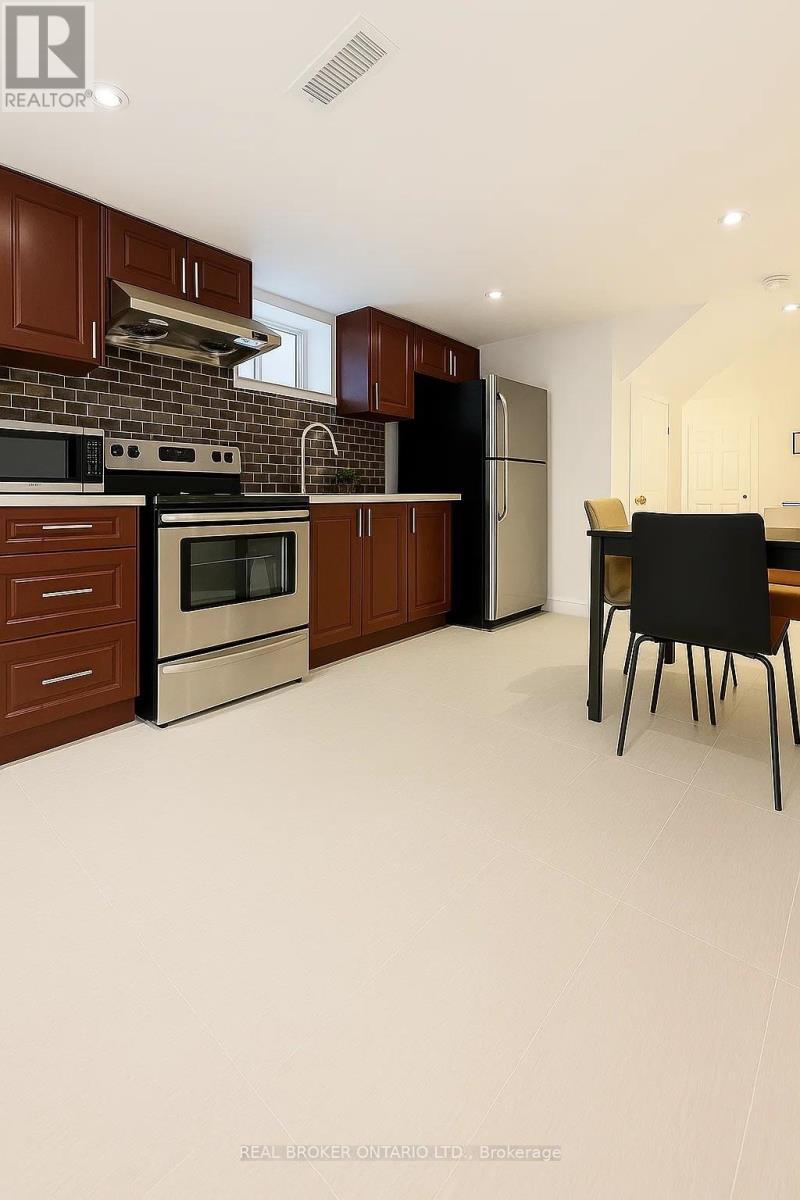 A kitchen with brown cabinets and a black fridge.
