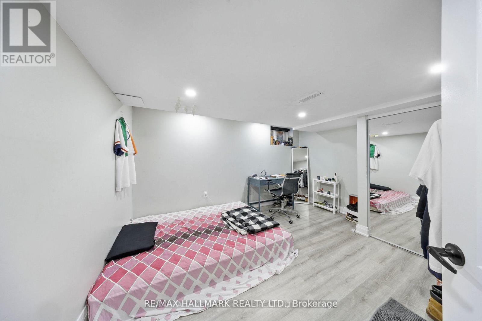 A bedroom with a bed, desk, and chair.