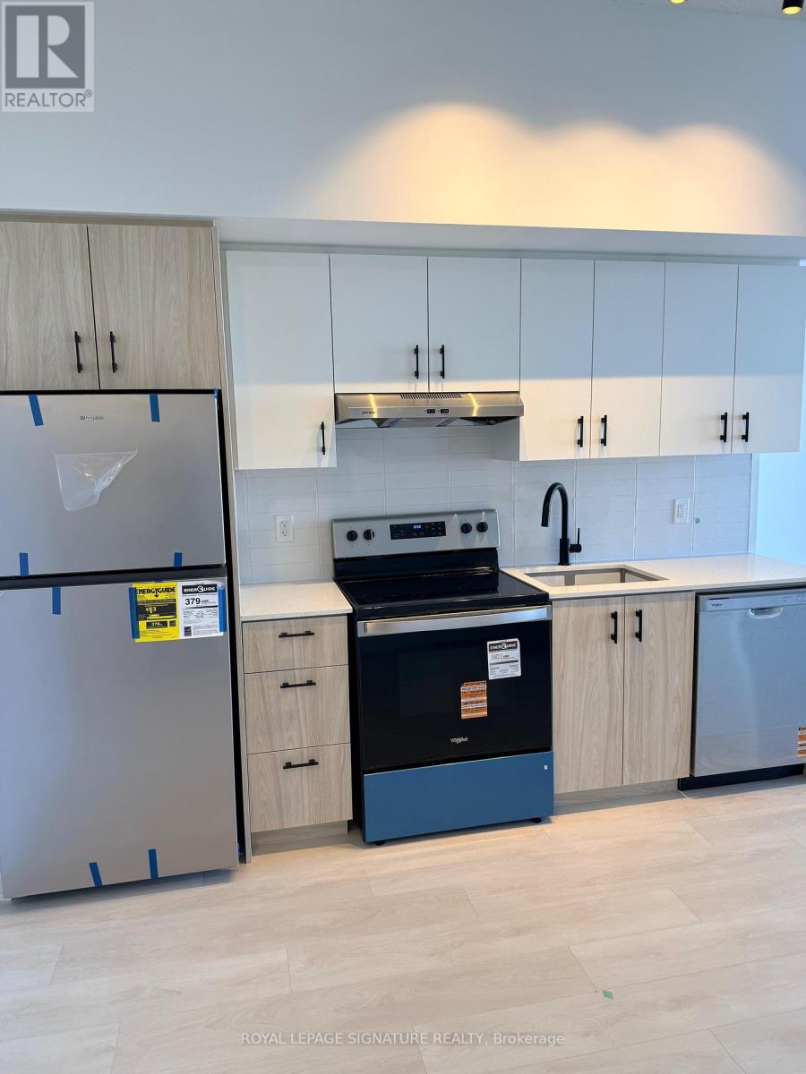 A kitchen with a refrigerator, oven, and cabinets.