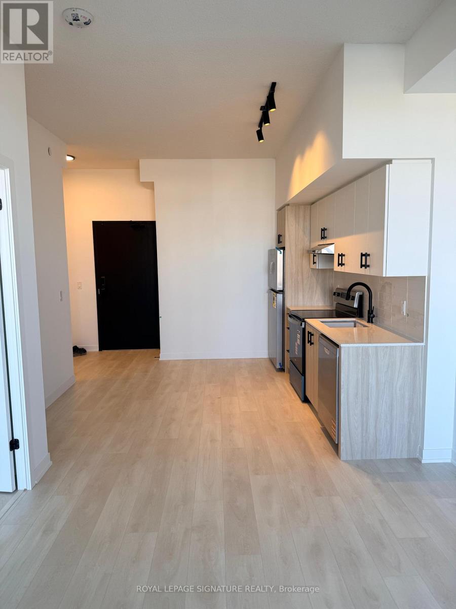 A kitchen area with wooden flooring and white walls.