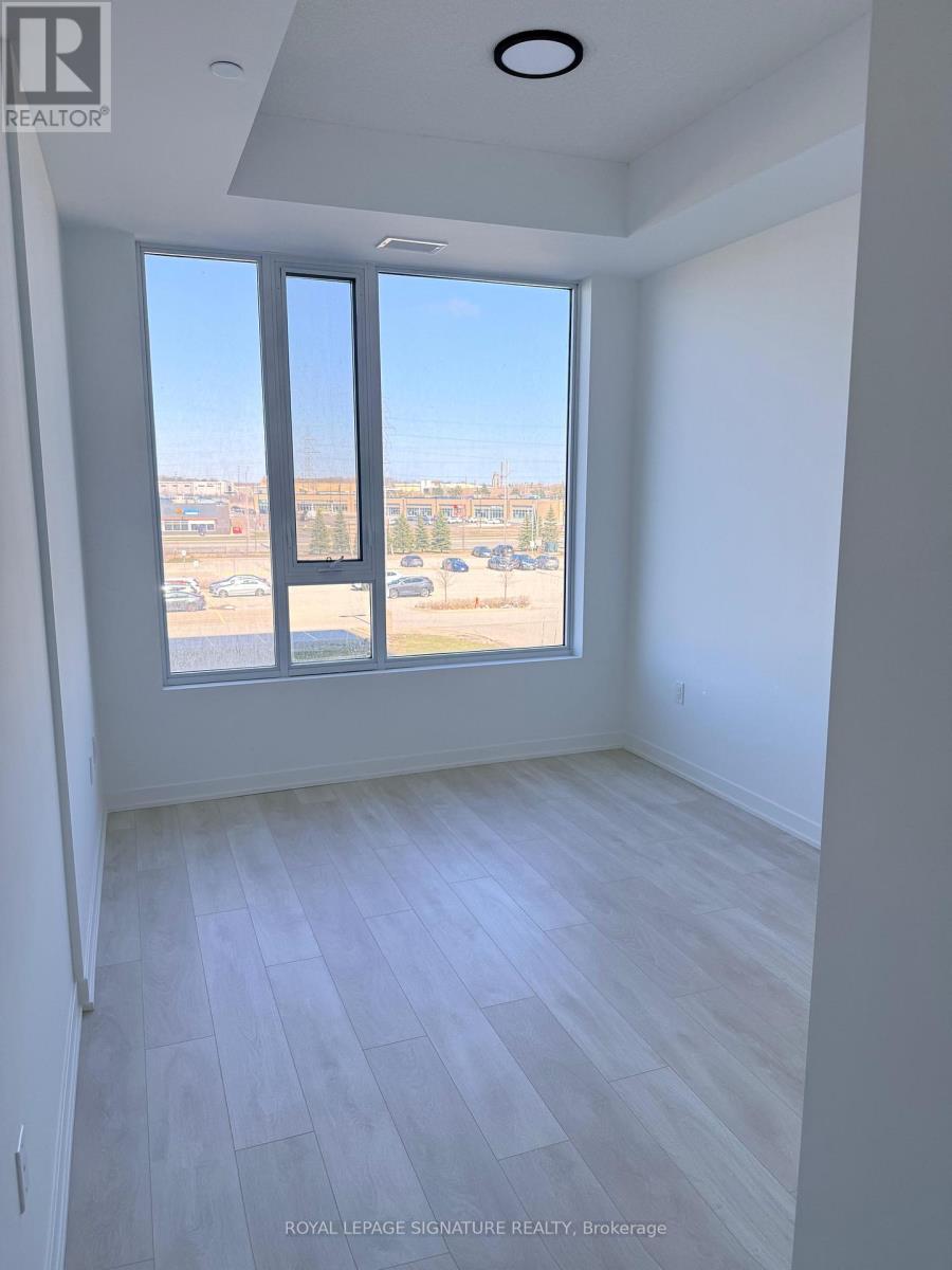 A room with a large window overlooking a parking lot.