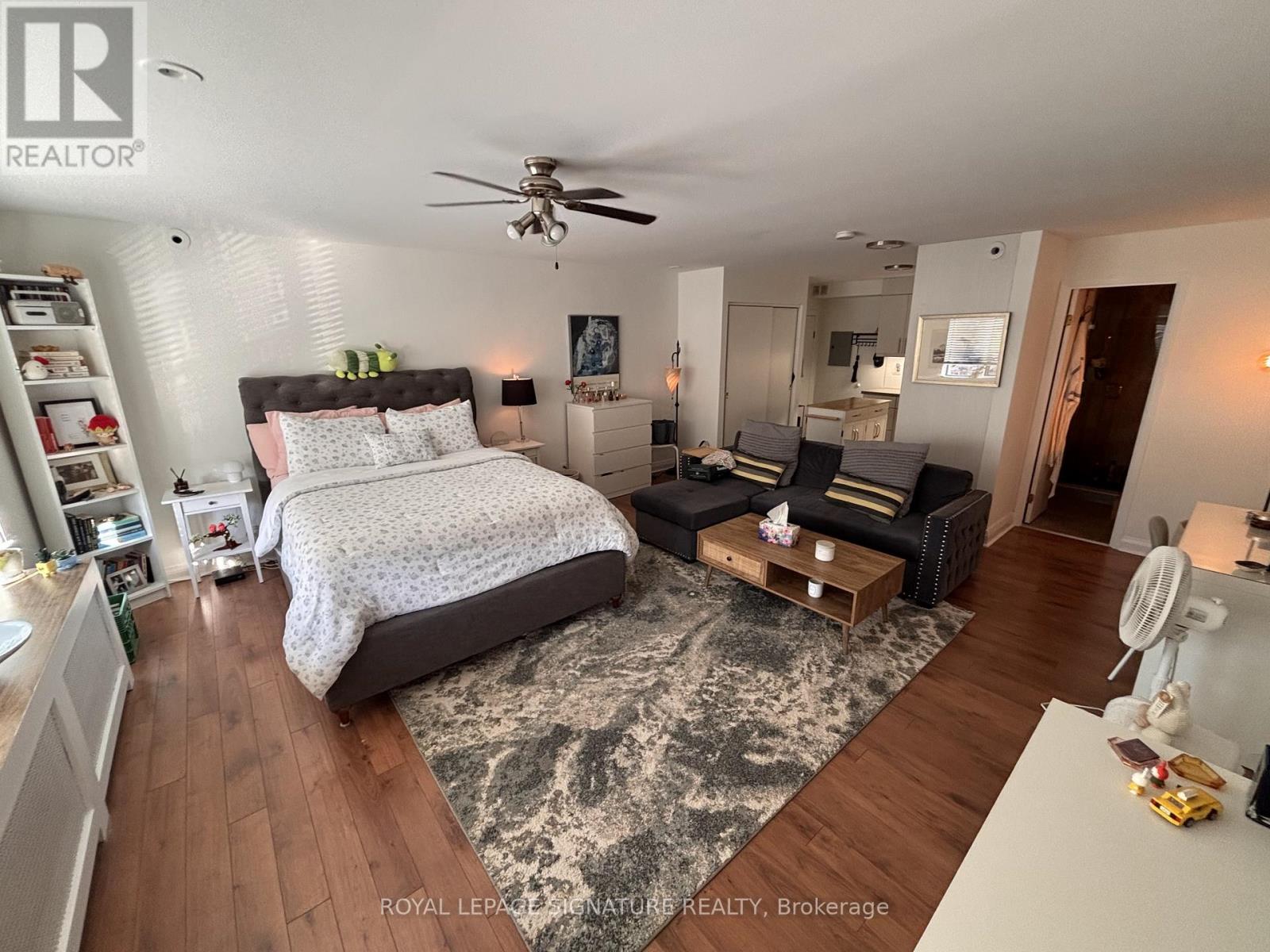 A bedroom with a large bed and a ceiling fan.