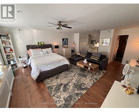 A bedroom with a large bed and a ceiling fan.