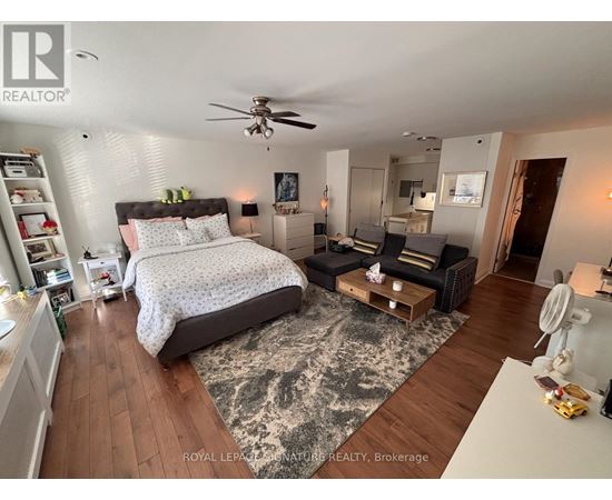 A bedroom with a large bed and a ceiling fan.