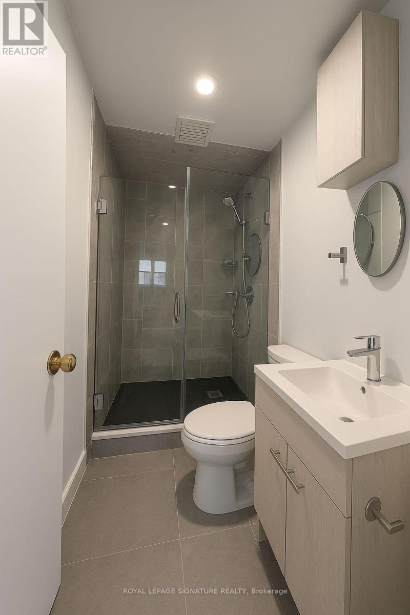 A white toilet sits in a bathroom next to a sink.