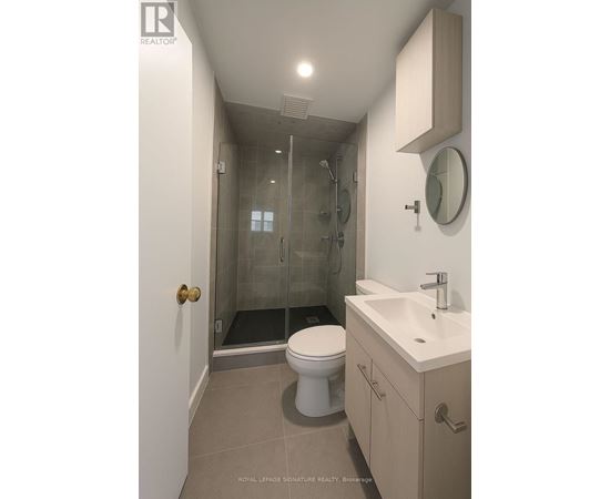 A white toilet sits in a bathroom next to a sink.
