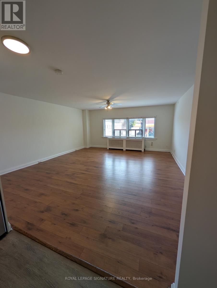 A room with wooden flooring and a window with blinds.