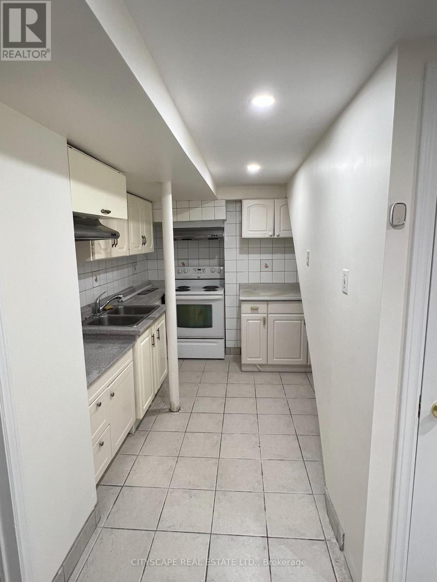 A white kitchen with tile flooring and white cabinets.