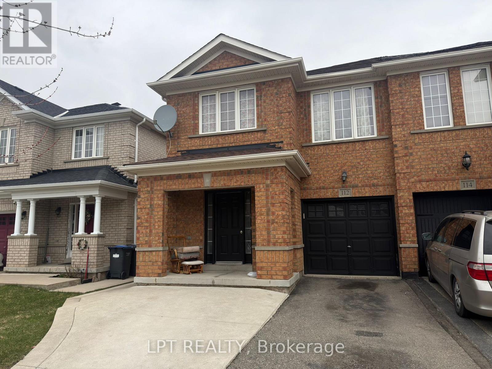A house with a brick facade and a garage door is for sale.