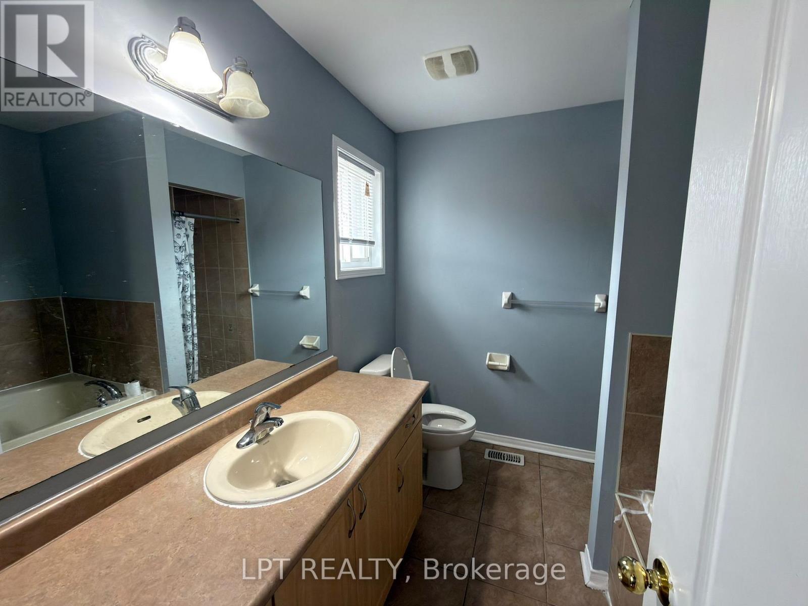 A bathroom with a sink, mirror, toilet, and shower.