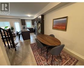 A dining room with a wooden table and chairs.