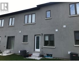 A grey building with a white door and windows.