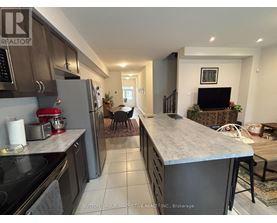 A kitchen with a refrigerator, stove, and a counter with a mixer on it.