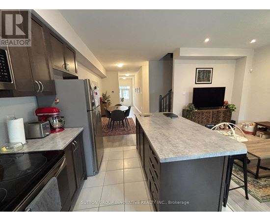 A kitchen with a refrigerator, stove, and a counter with a mixer on it.