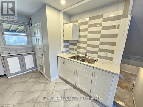 A kitchen with white cabinets and a checkered backsplash.