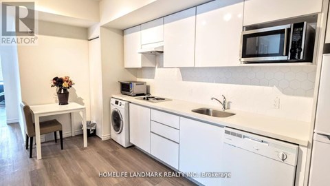 A kitchen with white cabinets and appliances, a sink, a microwave, and a dishwasher.