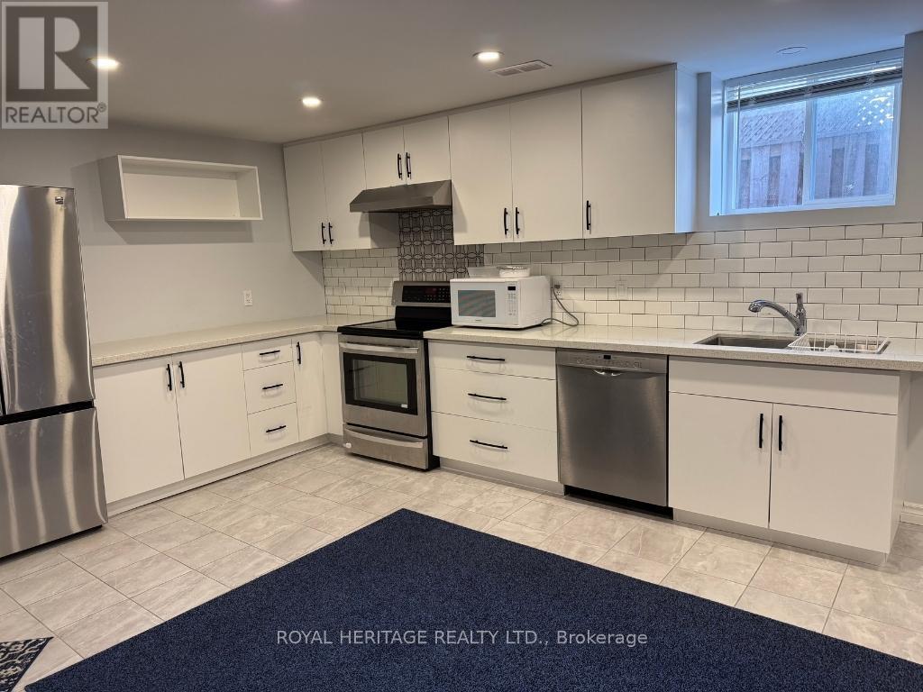 A kitchen with white cabinets and a blue rug in front.