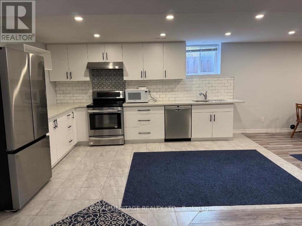 A kitchen with white cabinets and a stainless steel refrigerator.