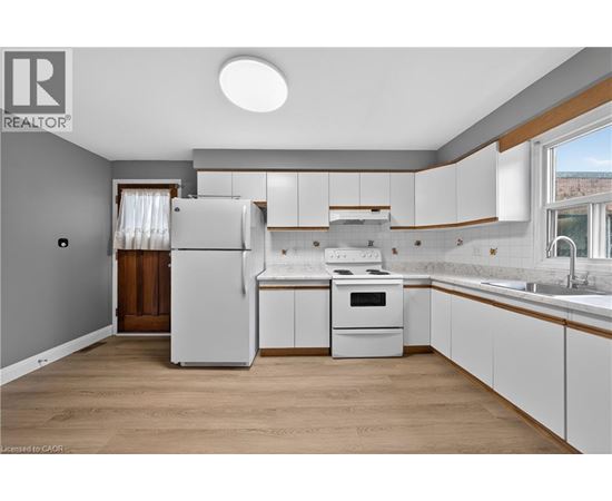 A kitchen with white cabinets and a refrigerator.