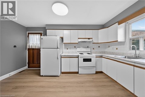 A kitchen with white cabinets and a refrigerator.