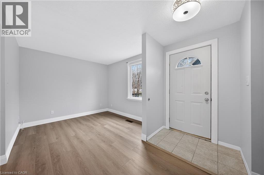 A room with a white door and a window with a view of trees.