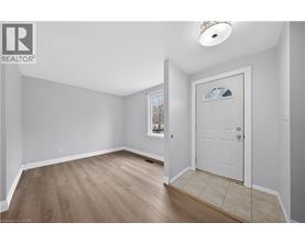 A room with a white door and a window with a view of trees.