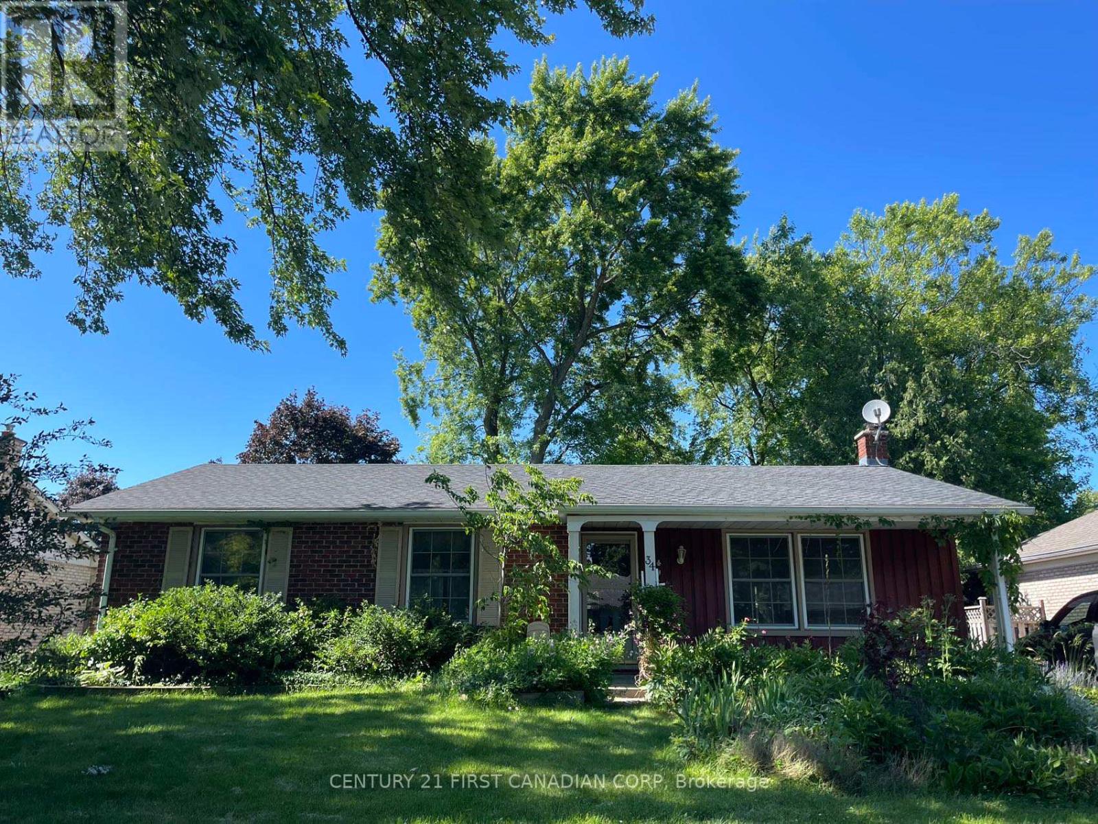 A house with a sign that says "Century 21 First Canadian Corp Brokers".