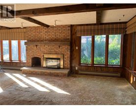 A room with a fireplace and a window with a view of trees.