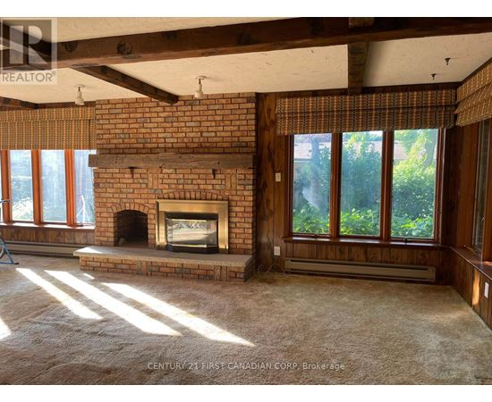 A room with a fireplace and a window with a view of trees.