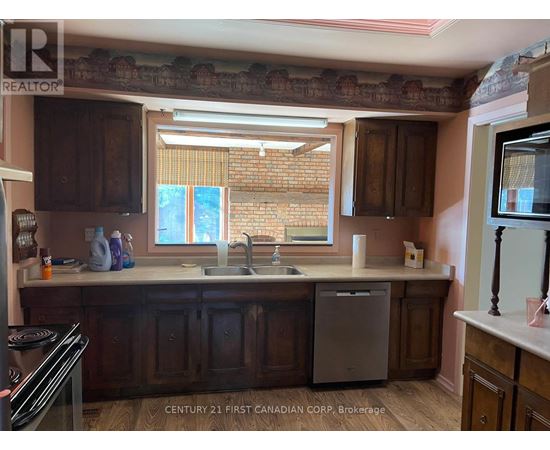A kitchen with wooden cabinets and a brick wall.