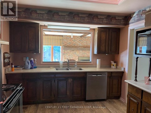 A kitchen with wooden cabinets and a brick wall.
