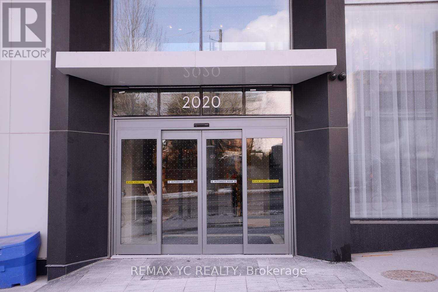 The front of a REALTOR building with a glass door and windows.