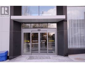 The front of a REALTOR building with a glass door and windows.