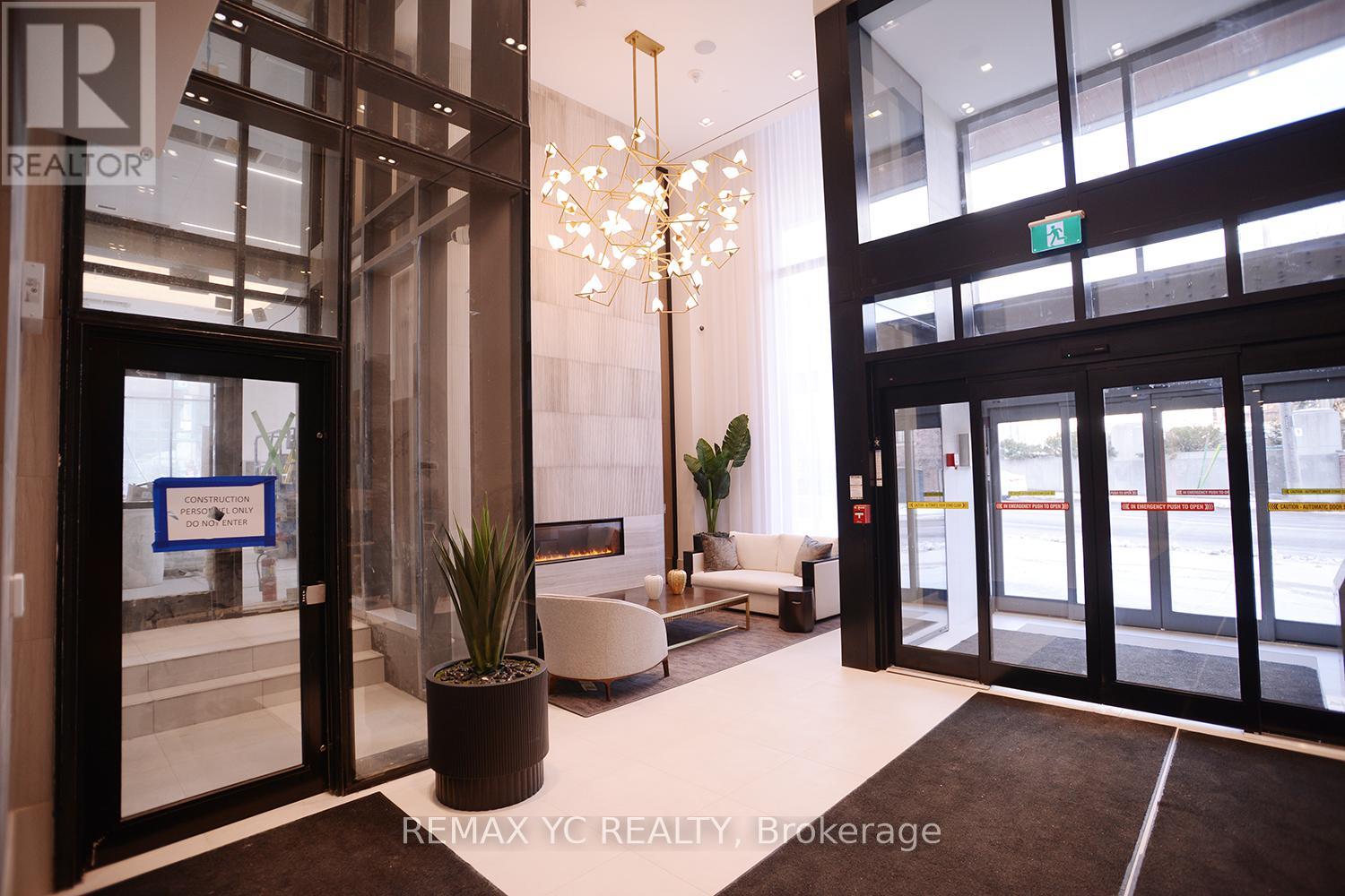 A chandelier hangs over a bench in a lobby.