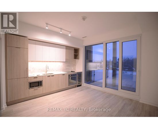 A modern kitchen with wooden cabinets and a large window.
