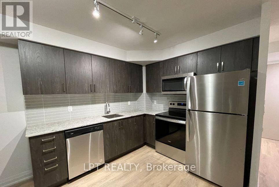 A kitchen with a refrigerator, dishwasher, and oven.