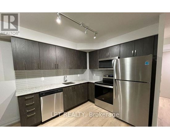 A kitchen with a refrigerator, dishwasher, and oven.