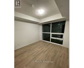 A room with wooden flooring and a window with blinds.