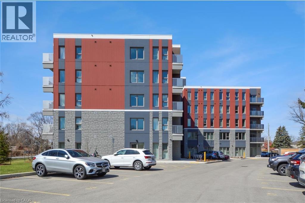 A modern multi-story building with a parking lot in front.