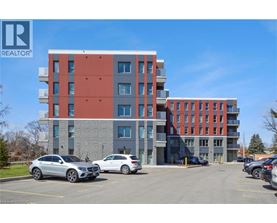 A modern multi-story building with a parking lot in front.