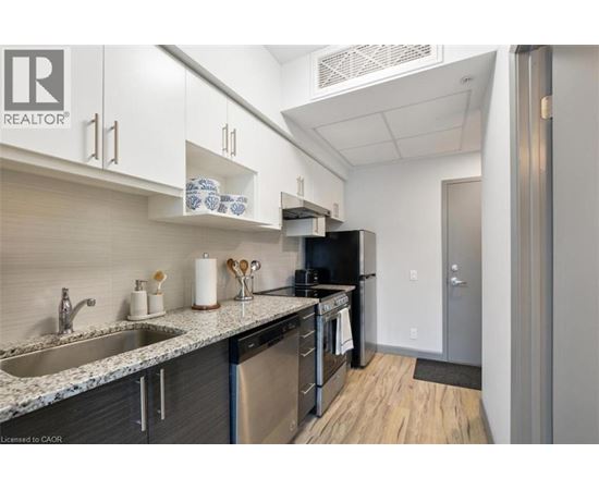A kitchen with a sink, stove, and refrigerator.