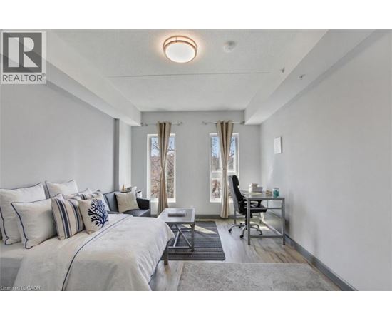 A bedroom with a large bed and a desk with a chair.